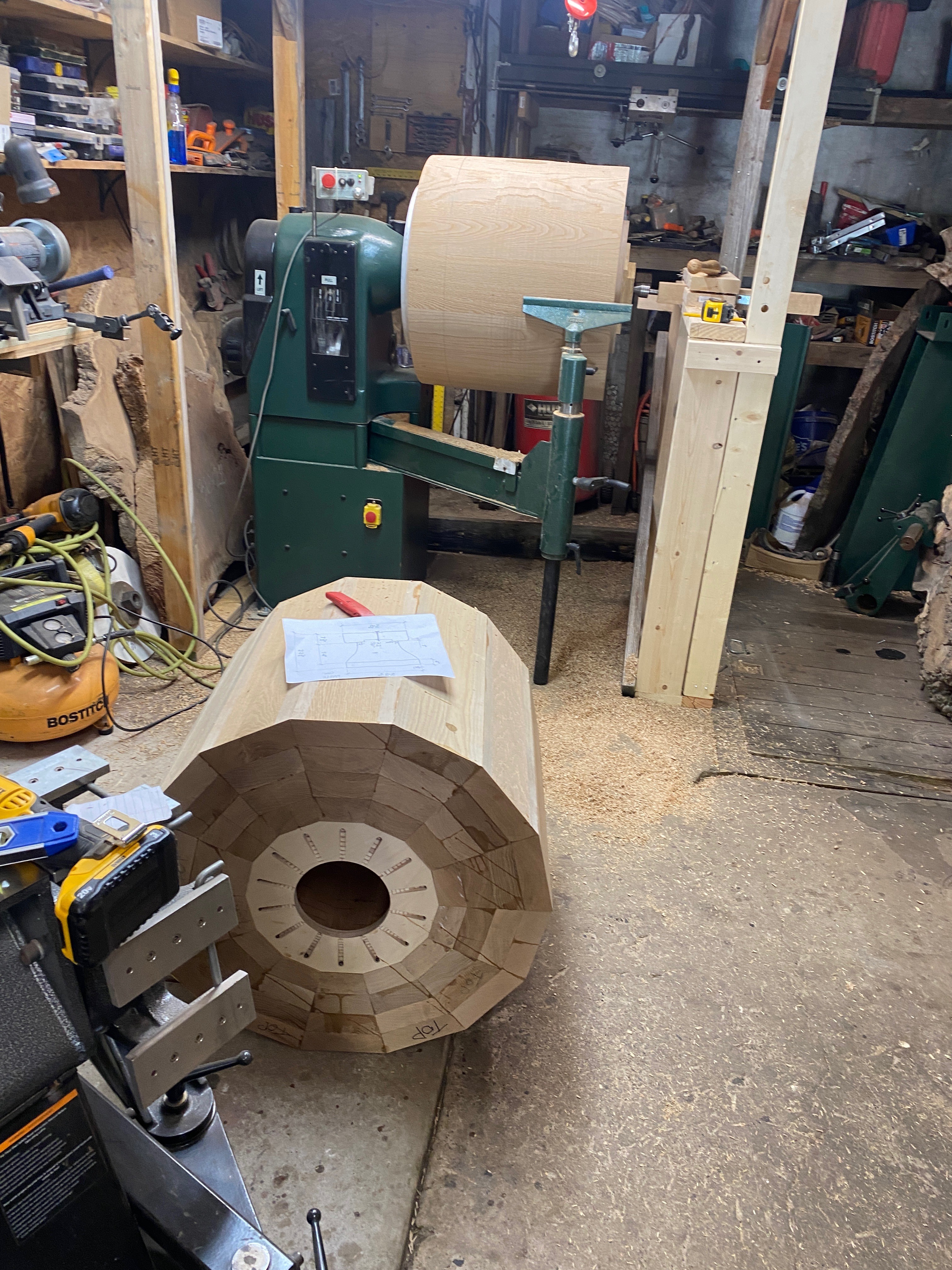Two blanks in the studio: one partially turned on the lathe, the second segmented blank waiting on the floor.